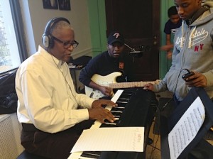 Howard Sandifer, left, guitar instructor Wilbert Crosby, center, work with students at the CWCMC 2