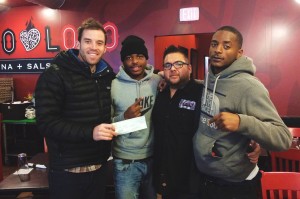 Friends Matt Jones (left), Antwon Love (second from left) and Tevin Russell (far right) celebrate a sponsorship check they received for their church basketball team.
