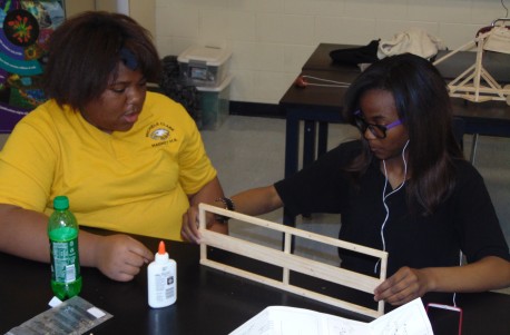 Kadeijah Bailey, 15, and Nya Mitchell, 16, both freshmen building catapults in Michele Clark High School's  STEM (Science, Technology, Engineering and Mathematics) program. (Photo/Terry Dean)